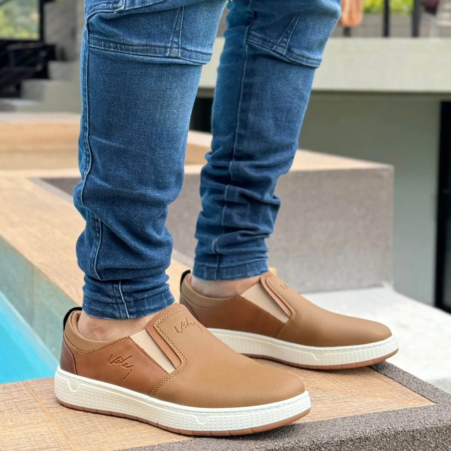 Mocasin Ebano flexibles para hombre en color marrón claro con suela blanca antideslizante, diseño slip-on cómodo y elegante perfecto para uso diario, que ofrece soporte ergonómico y material resistente para mayor durabilidad y estilo casual moderno.
