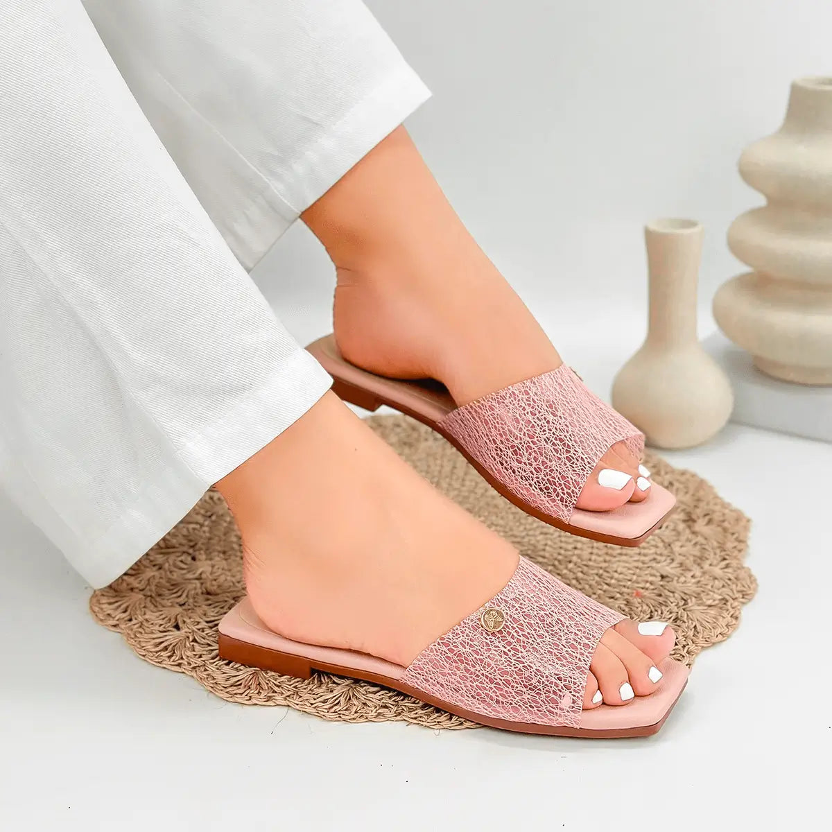 Sandalias femeninas color rosa claro con diseño abierto, suela plana y detalle texturizado, ideales para uso diario que combinan comodidad y estilo para pie descubierto en clima cálido.