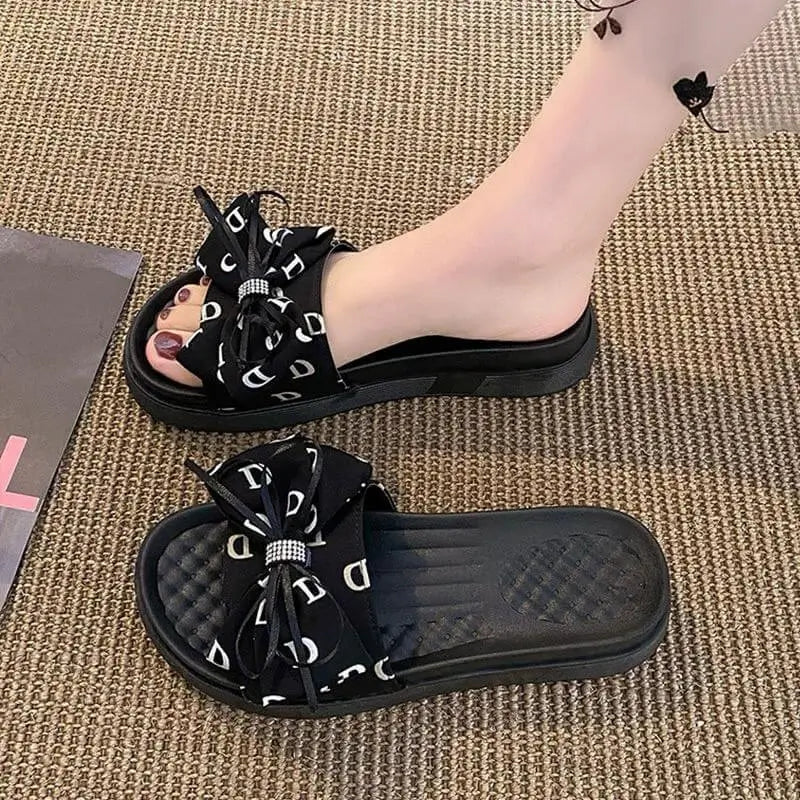 Sandalias negras para mujer tipo slide con moño decorativo, plantilla acolchonada para mayor comodidad y suela antideslizante, ideales para uso diario, frescas y ligeras perfectas para caminar largas distancias sin fatiga.