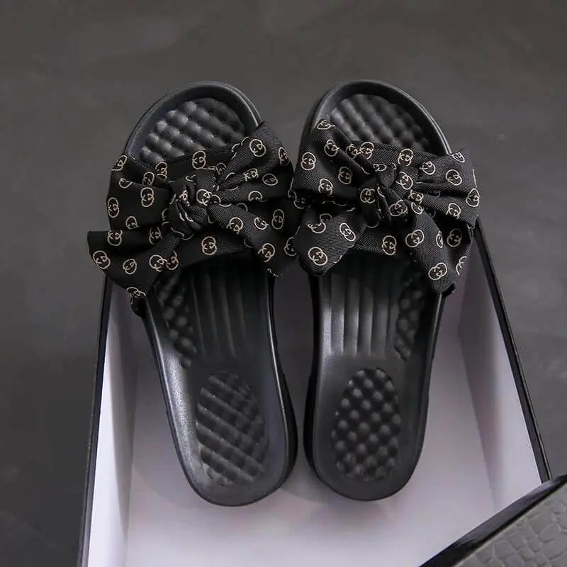 Sandalias negras para mujer con diseño de lazo elegante, suela acolchonada cómoda y material resistente, ideales para uso diario que ofrece frescura y soporte ergonómico en cada paso.