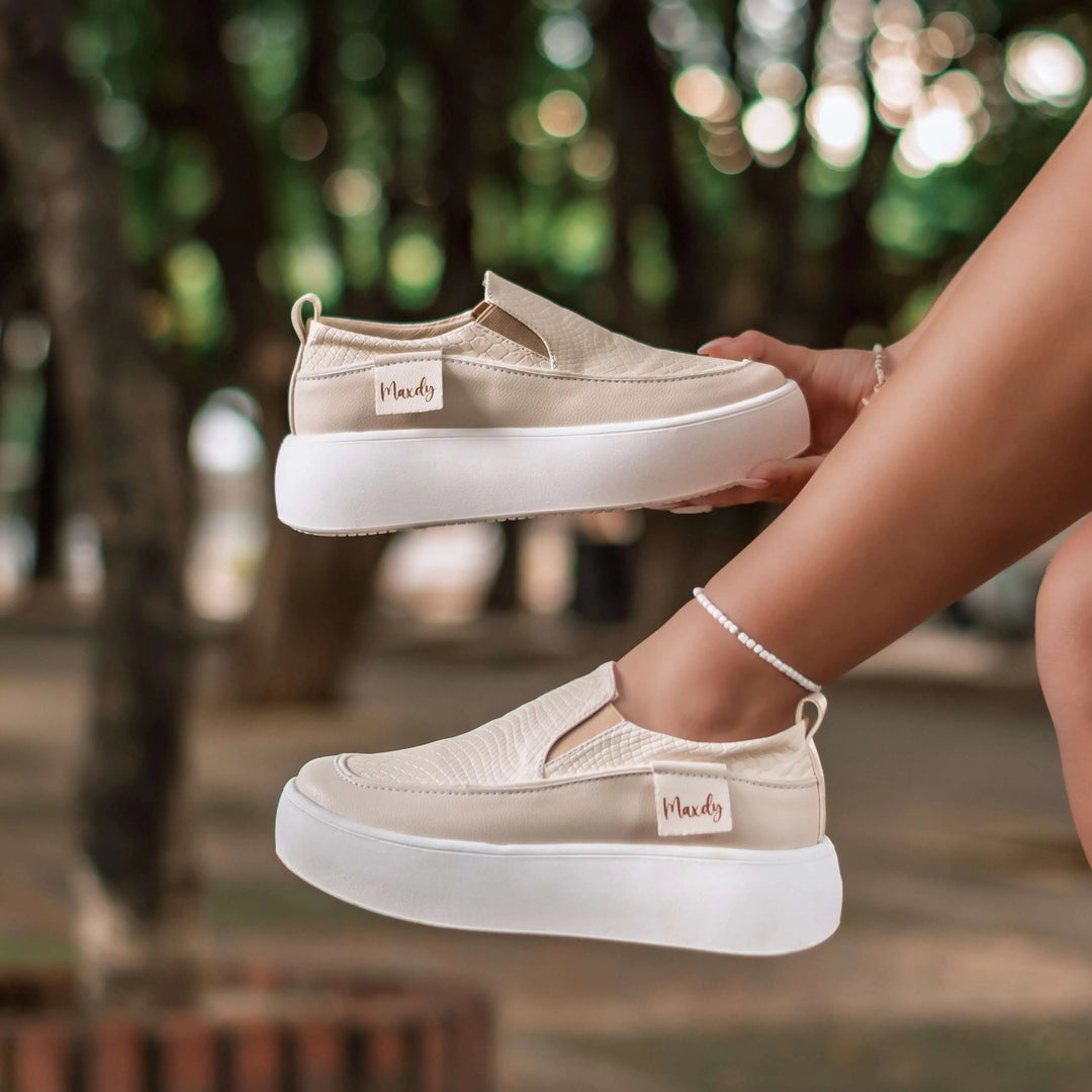 Mocasín beige para mujer con diseño moderno y cómodo, suela blanca gruesa antideslizante, material flexible que brinda soporte y estilo casual ideal para uso diario en ciudad y oficina.