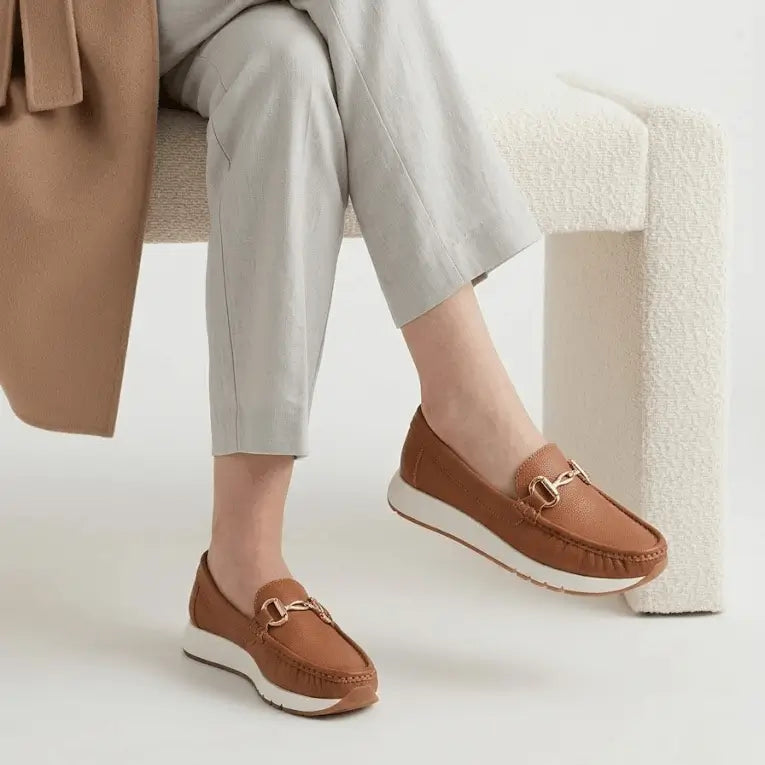 Mocasines para mujer color caramelo con suela blanca antideslizante, detalle metálico dorado, plantilla acolchada y diseño ergonómico que brinda confort y estilo casual elegante para uso diario