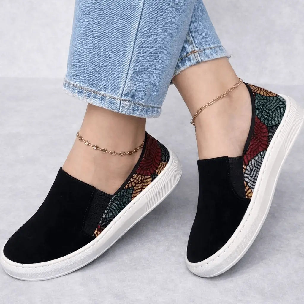 Zapato slip-on para mujer en negro con estampado geométrico multicolor, suela blanca antideslizante y plantilla acolchada que garantiza comodidad todo el día, ideal para looks casuales y urbanos