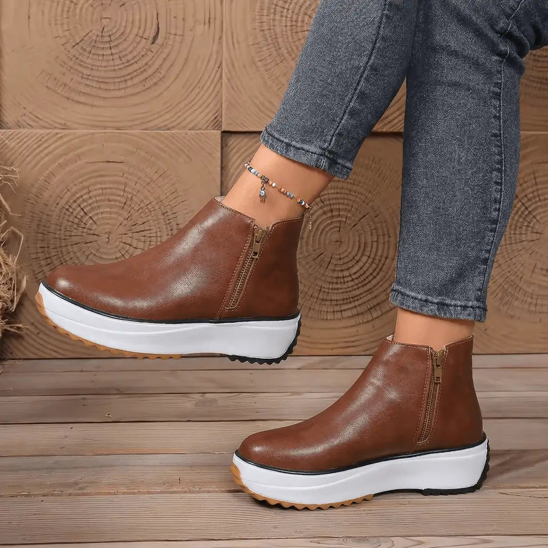 Botín Luxe mujer en cuero sintético café con cremallera lateral, plataforma blanca, suela antideslizante y plantilla acolchada para máxima comodidad urbana