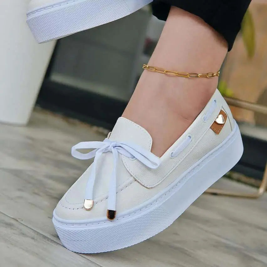 Mocasín blanco para mujer con diseño cómodo y casual, suela gruesa antideslizante, detalle de corazón metálico, ideal para uso diario y combinar con estilos modernos, hecho con materiales duraderos y frescos para mayor confort.