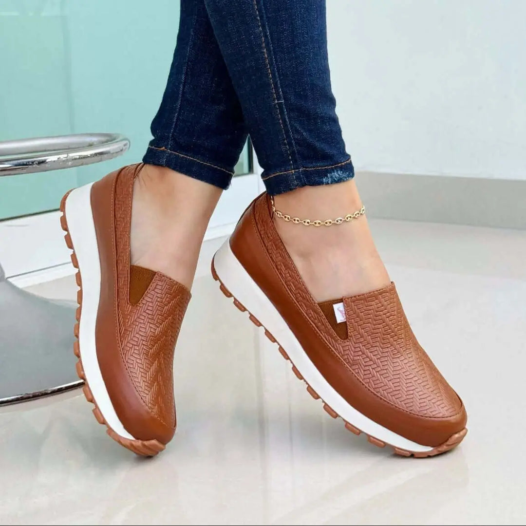 Mocasín para mujer color cuero con diseño texturizado antideslizante, suela blanca con agarre ideal para uso diario, calzado cómodo y ligero perfecto para combinar con jeans ajustados, ofrece confort y estilo casual para caminar largas distancias.