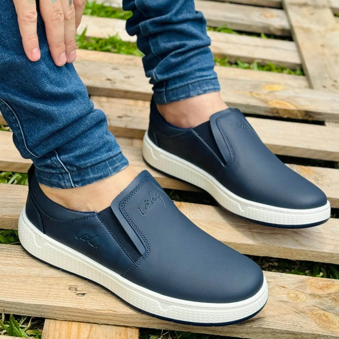 Mocasin Ebano para hombre en color azul marino, diseño casual y moderno, suela blanca antideslizante para mayor seguridad, material flexible y cómodo ideal para uso diario y urbano, perfectas para combinar con jeans ajustados.