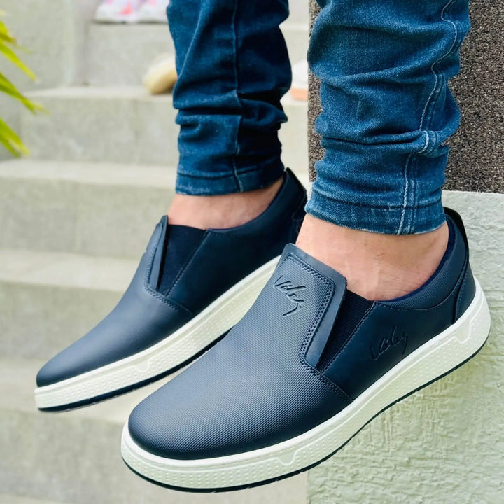 Mocasin Ebano para hombre en color azul oscuro con suela blanca antideslizante, diseño slip-on cómodo y moderno ideal para uso diario, material flexible y transpirable que garantiza comodidad y soporte en caminatas urbanas, perfecto para combinar con jeans y estilo casual.