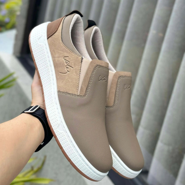 Mocasin Ebano Casuales para hombre en tono beige, diseño slip on con suela blanca antideslizante, ideales para uso urbano y diario, material transpirable y flexible que brinda comodidad y soporte durante todo el día.