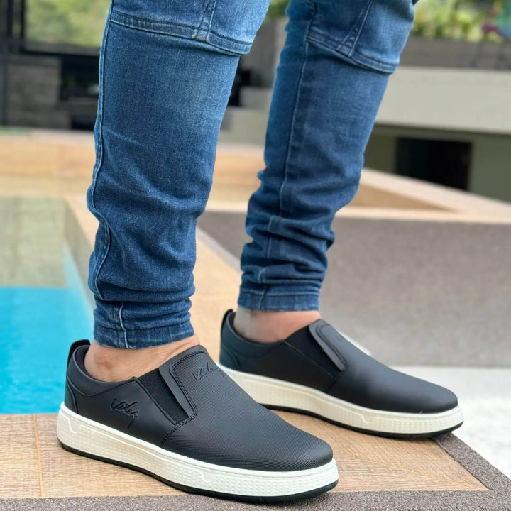 Calzado casual tipo zapatillas urbanas color negro con suela blanca antideslizante, diseño cómodo y moderno ideal para uso diario, fácil de combinar con jeans y ropa urbana, zapatillas livianas y flexibles que brindan soporte y confort para caminar todo el día.