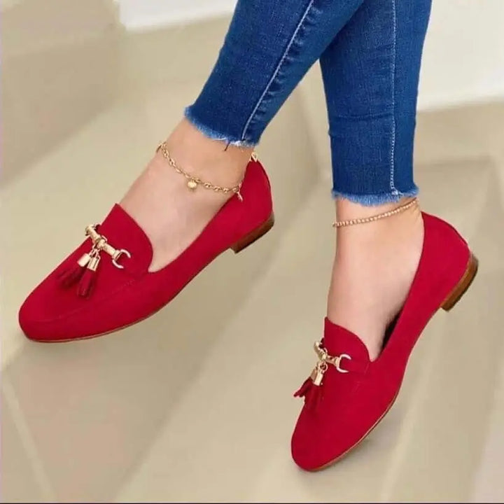 Mocasines rojos para mujer con diseño elegante y cómodo, detalles en metal dorado y borlas, suela plana antideslizante, ideales para uso diario y combinan con jeans ajustados, calzado versátil que ofrece confort y estilo para cualquier ocasión.