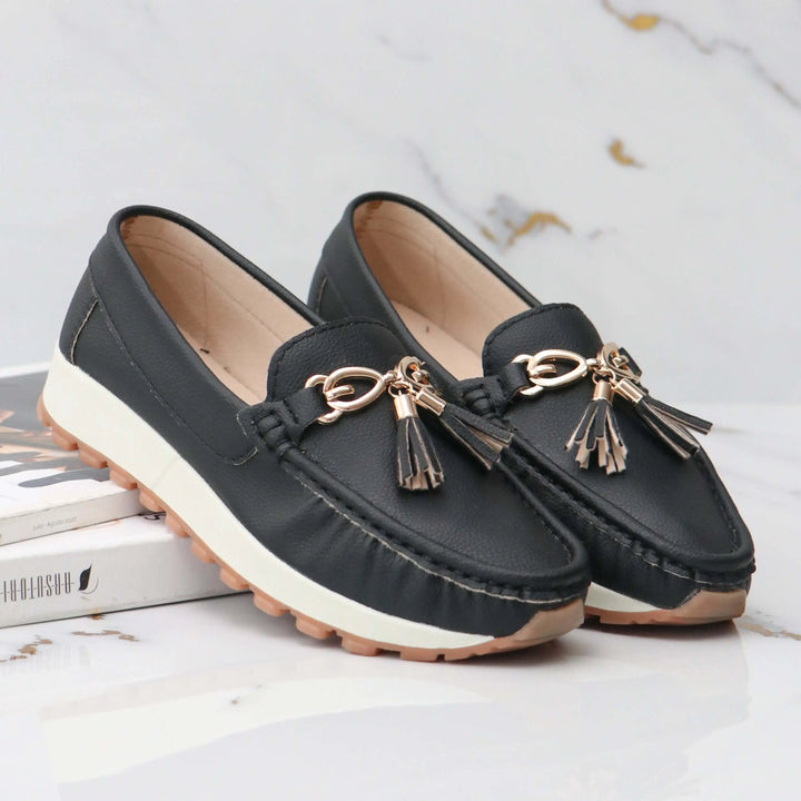 Mocasines negros para mujer estilo elegante y casual, fabricados en cuero sintético premium con suela antideslizante ideal para uso diario, comodidad y diseño con detalle en borlas doradas que realzan cualquier look.