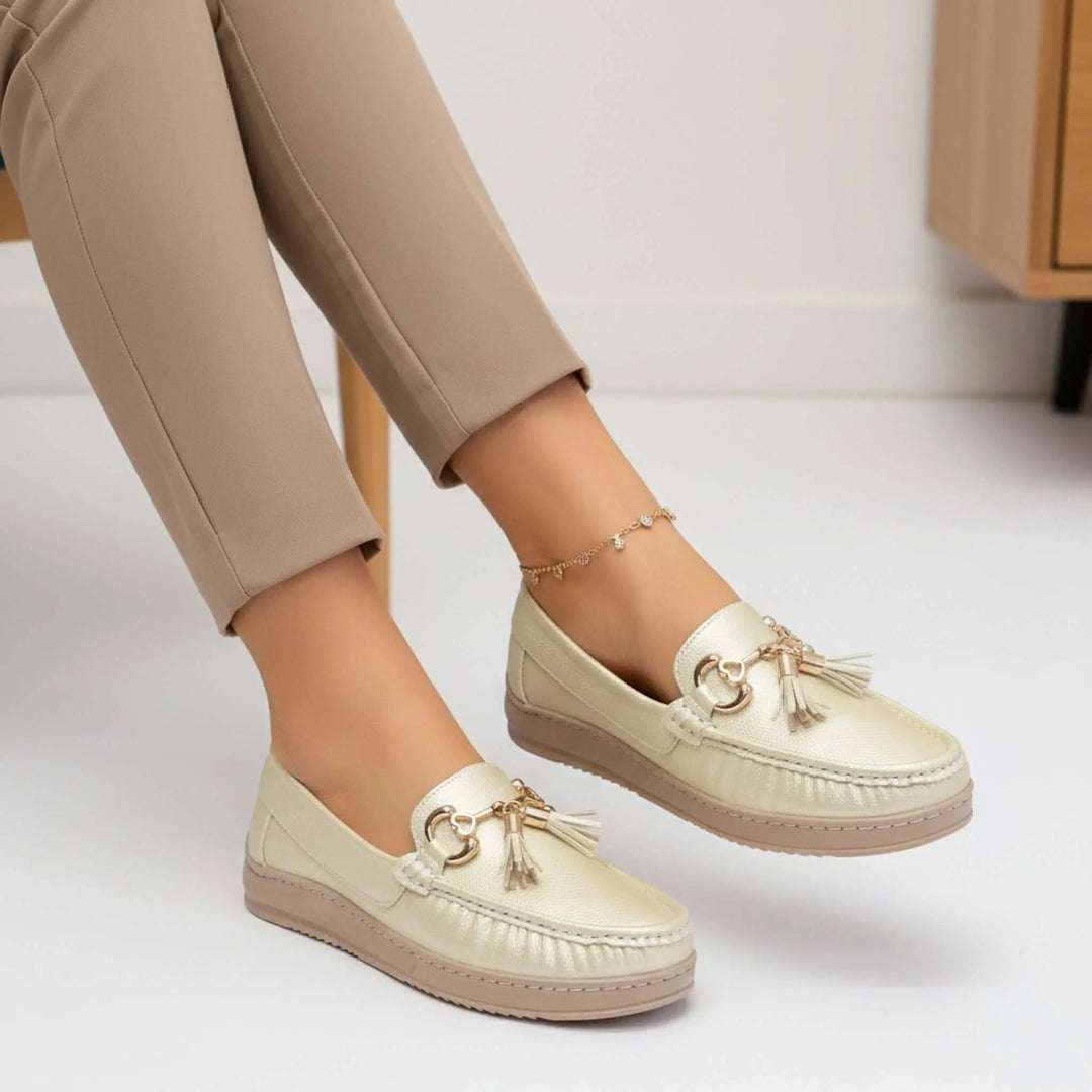 Mocasines para mujer color beige dorado con detalles en flecos y herrajes metálicos, diseño cómodo y casual ideal para uso diario, suela antideslizante y plantilla acolchada que ofrece confort durante todo el día, perfecto para combinar con pantalones formales o casuales en temporada primavera-verano.