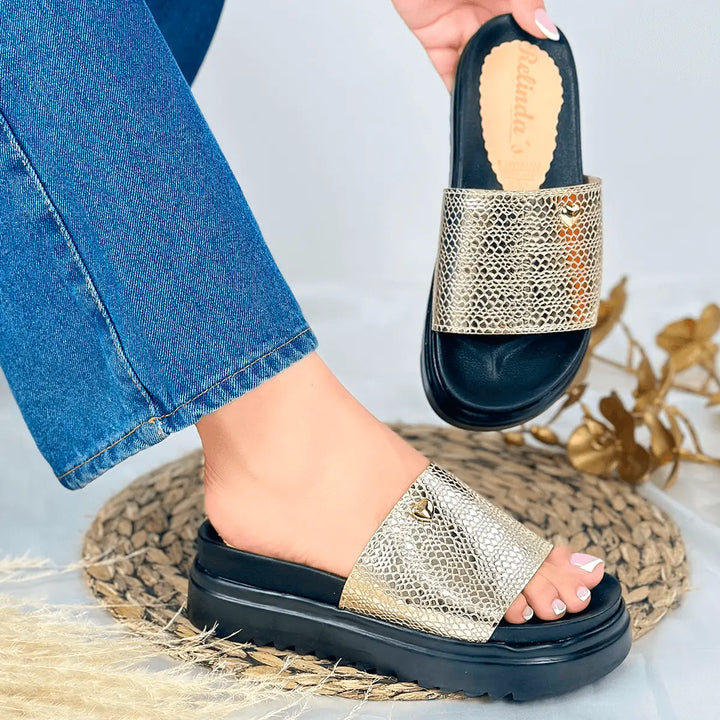 Sandalias de cuero dorado con plataforma negra, diseño cómodo y moderno ideal para uso diario, suela antideslizante y material resistente que garantiza durabilidad y estilo elegante para combinar con diferentes outfits casuales y formales.