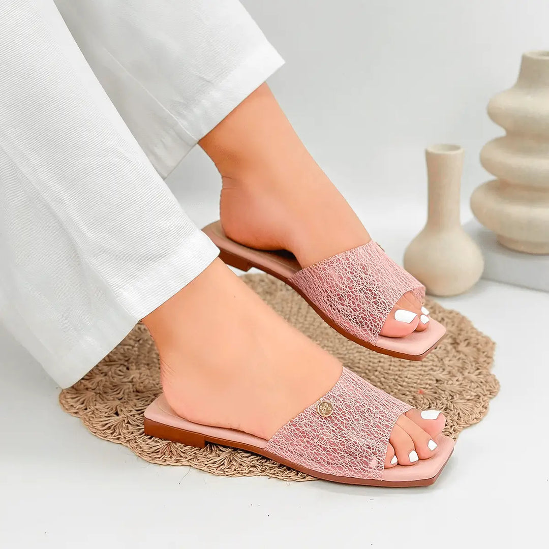 Sandalias femeninas color rosa claro con diseño abierto, suela plana y detalle texturizado, ideales para uso diario que combinan comodidad y estilo para pie descubierto en clima cálido.