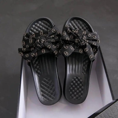 Sandalias negras para mujer con diseño de lazo elegante, suela acolchonada cómoda y material resistente, ideales para uso diario que ofrece frescura y soporte ergonómico en cada paso.