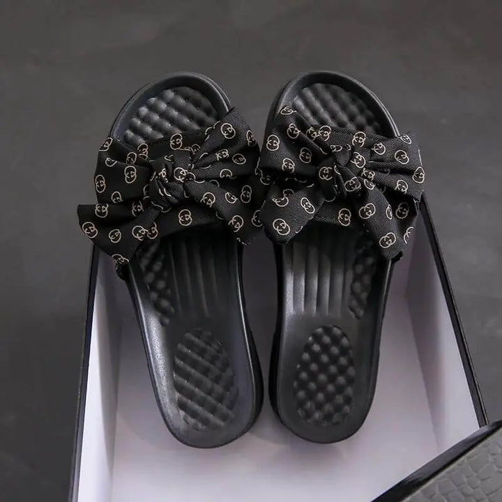 Sandalias negras para mujer con diseño de lazo elegante, suela acolchonada cómoda y material resistente, ideales para uso diario que ofrece frescura y soporte ergonómico en cada paso.
