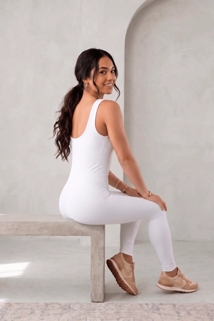 Mujer de perfil con skinny entero moldeador blanco sin costuras y tirantes anchos, efecto compresivo para alisar abdomen, realzar cintura y glúteos, mejorar postura y ofrecer soporte ligero con tejido transpirable.