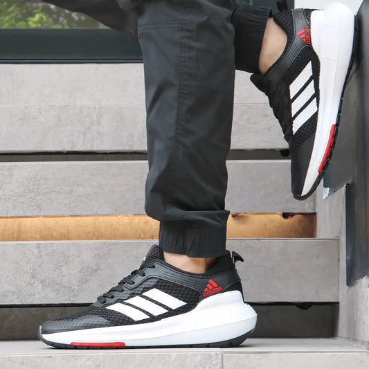 Tenis deportivo negro con detalles en blanco y rojo, diseño liviano y transpirable ideal para correr y entrenamiento, suela acolchonada para máxima comodidad y soporte en cada paso, calzado urbano moderno para hombres buscando rendimiento y estilo.