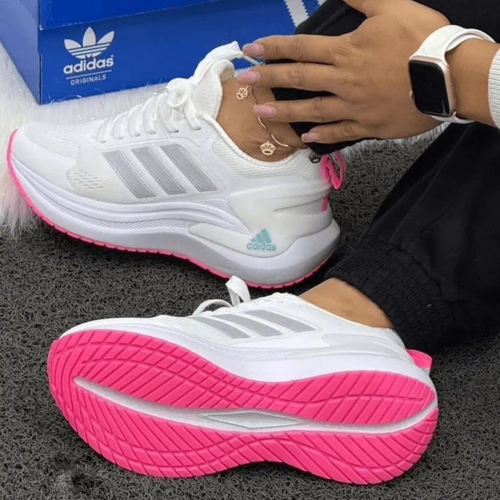 Imagen de zapatillas deportivas Bounce en color blanco con suela antideslizante rosa, malla transpirable y entresuela acolchada que ofrece amortiguación reactiva y confort urbano todo el día