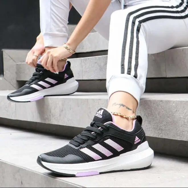 Zapatillas deportivas negras con detalles en rosa pastel, diseño ligero y transpirable, suela de goma antideslizante ideal para ejercicio y uso diario, perfectas para estilo urbano y comodidad prolongada.