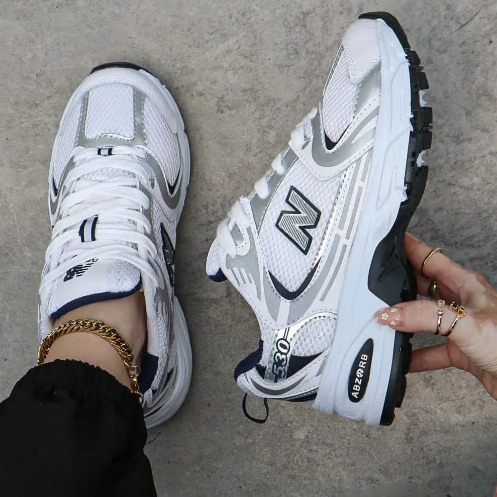 Zapatillas deportivas blancas con detalles en gris y negro, diseño ligero y transpirable ideal para correr y uso diario, suela antideslizante y amortiguación avanzada para máximo confort y soporte durante todo el día, calzado perfecto para estilo casual y entrenamiento fitness.