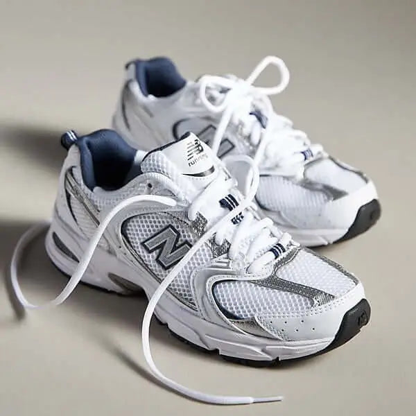 Zapatillas deportivas blancas con detalles gris oscuro, diseño transpirable con malla y tela resistente, suela antideslizante para mayor seguridad y comodidad, ideales para correr, entrenar y uso diario, calzado ligero y ergonómico que brinda soporte y absorción de impactos para proteger tus pies mientras haces ejercicio.