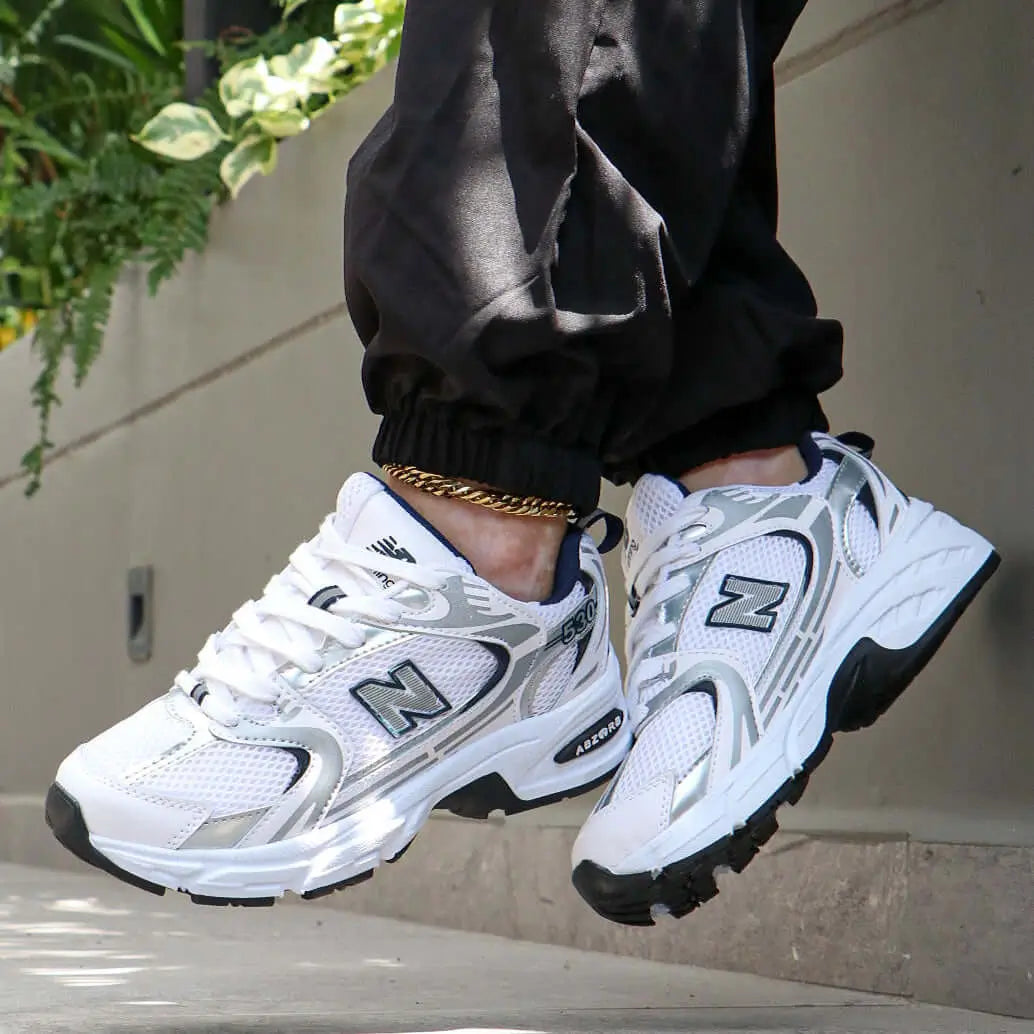 Zapatillas deportivas blancas con detalles grises y negros, diseño moderno y transpirable, suela antideslizante y amortiguación avanzada para máxima comodidad y soporte durante actividades diarias y deportivas, ideales para hombres que buscan estilo y funcionalidad.