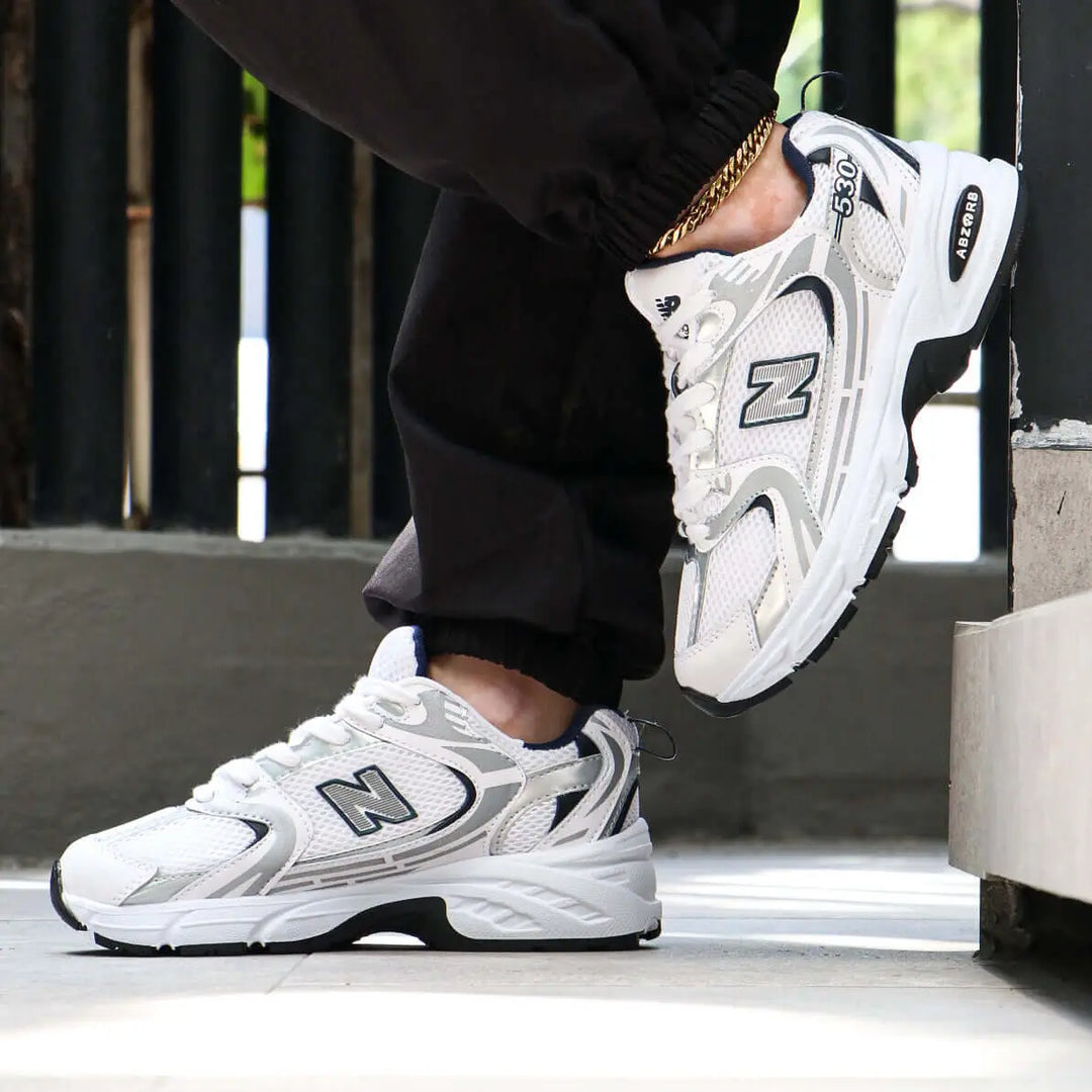 Tenis deportivos blancos con detalles grises y negros diseñados para máxima comodidad y soporte, suela antideslizante ideal para actividades diarias, calzado ligero y transpirable perfecto para uso urbano y entrenamiento, estilo moderno que combina con ropa casual, zapatillas de alta durabilidad y confort para hombres y mujeres.