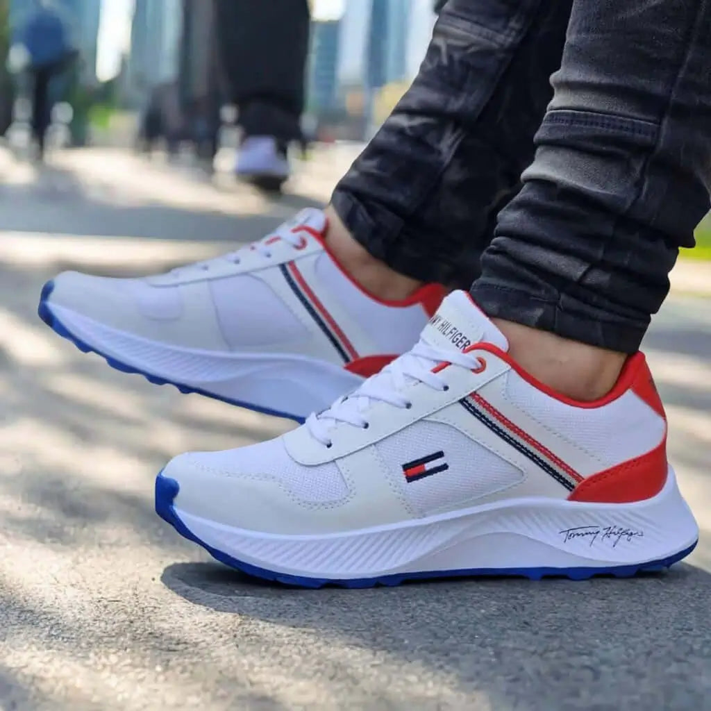 Zapatillas Legacy blancas con detalles en rojo y azul, diseño deportivo para hombre, suela antiderrapante para mayor seguridad, material liviano y transpirable que ofrece comodidad durante todo el día, ideales para uso urbano y casual, calzado deportivo elegante y versátil para cualquier ocasión.