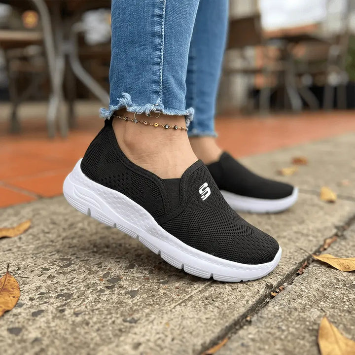 Zapatillas Luna negras slip-on de malla transpirable con suela blanca amortiguada y antideslizante, diseño ligero y ergonómico para máximo confort en caminatas, uso diario y actividades fitness