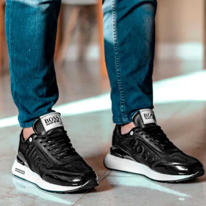 Zapatillas negras para hombre en ambiente interior, diseño moderno y deportivo con suela blanca antideslizante, fabricadas con materiales ligeros y transpirables que ofrecen comodidad y soporte ideal para uso diario y actividades casuales, combinan estilo y funcionalidad para un calzado versátil y duradero.