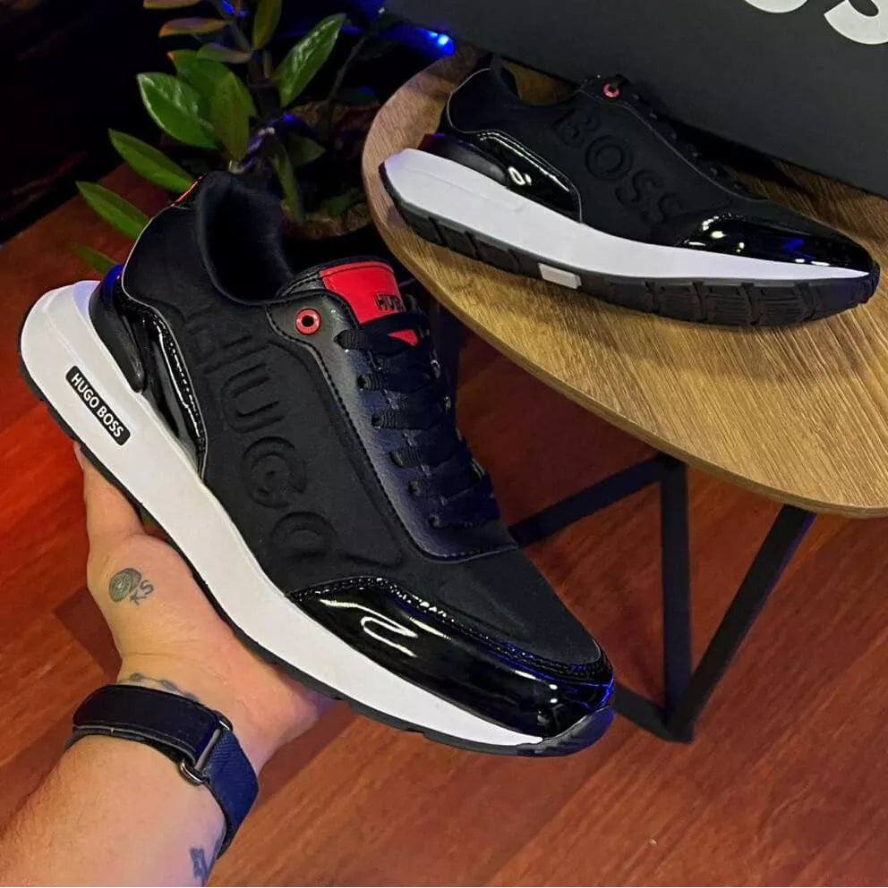 Zapatilla urbana de hombre color negro con detalles en brillo (charol) y suela tipo chunky blanca. Diseño moderno charol, urbanas, versatiles y elegantes