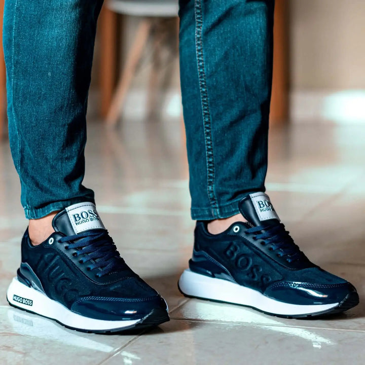 Zapatillas deportivas negras con suela blanca, diseño moderno y cómodo, ideales para uso diario, ofrecen soporte ergonómico, materiales transpirables y durabilidad, combinan con jeans y ropa casual para hombres jóvenes.