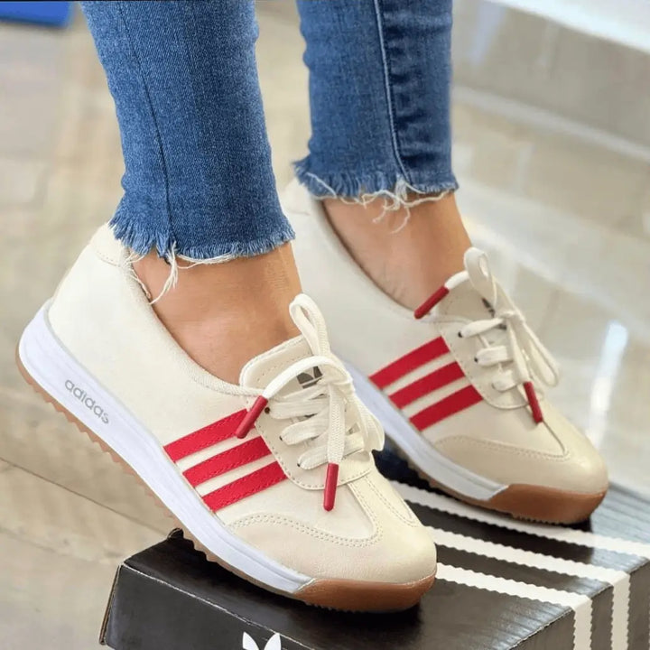 Zapatillas Marbella color marfil con franjas rojas combinables, suela antideslizante y amortiguación ergonómica, diseño retro-moderno que brinda confort y estilo casual para mujer en uso diario