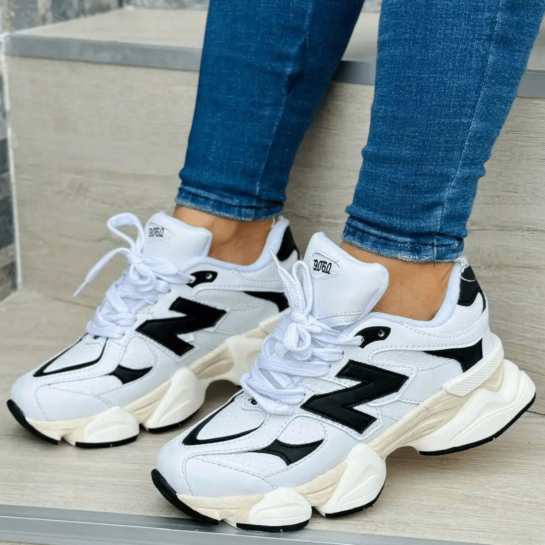 Zapatillas Noble blancas y negras con suela gruesa antideslizante y entresuela acolchada, diseño urbano deportivo para amortiguación y confort diario.