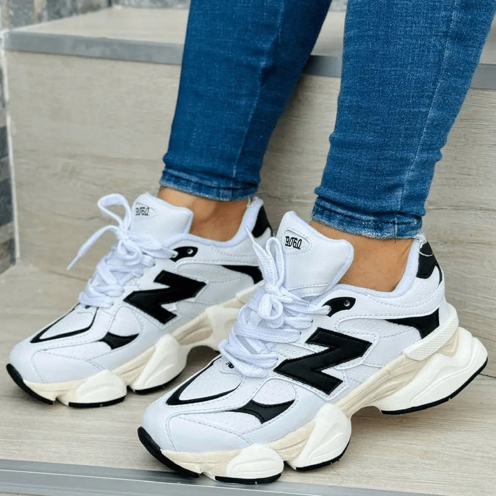 Zapatillas Noble blancas y negras con suela gruesa antideslizante y entresuela acolchada, diseño urbano deportivo para amortiguación y confort diario.