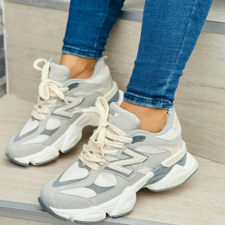 Zapatillas Noble color gris y beige con diseño urbano, malla transpirable y refuerzos en gamuza, suela acolchada antimpactos y antideslizante para máxima comodidad diaria
