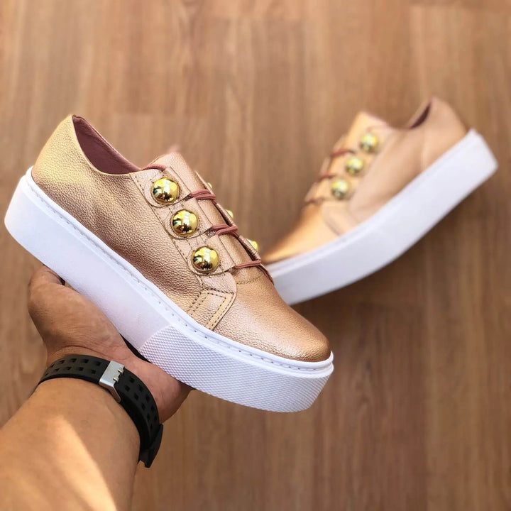 Zapatillas mujer color oro rosa con plataforma blanca, diseño moderno con botones dorados decorativos, suela antideslizante y amortiguación para máxima comodidad y estilo casual urbano.