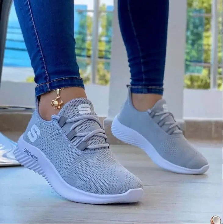 Zapatillas Soft color gris claro con diseño transpirable de tejido mesh, suela blanca antideslizante, ideales para uso diario y actividades deportivas, ofrecen comodidad y soporte ergonómico para el pie, perfectas para estilos casuales y urbanos en Colombia.
