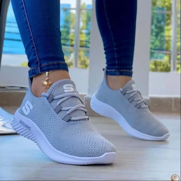 Zapatillas Soft color gris claro con diseño transpirable de tejido mesh, suela blanca antideslizante, ideales para uso diario y actividades deportivas, ofrecen comodidad y soporte ergonómico para el pie, perfectas para estilos casuales y urbanos en Colombia.