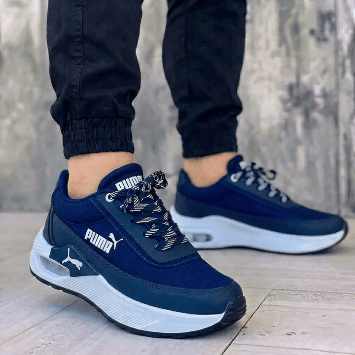Zapatillas Puma para hombre color azul marino con suela blanca y cámara de aire. Calzado deportivo casual.