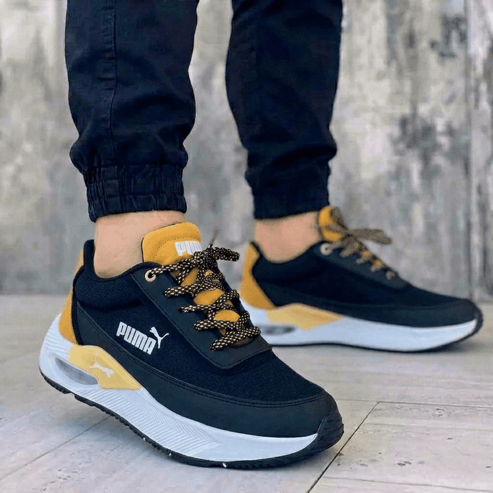 Zapatillas Puma para hombre negras y amarillas con plataforma y amortiguación. Calzado deportivo casual con suela blanca gruesa.