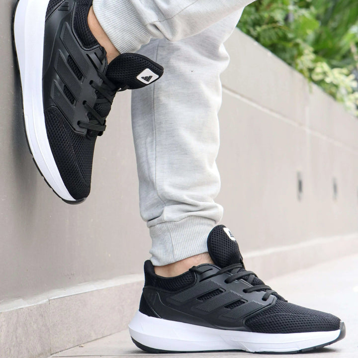 Zapatillas deportivas negras con suela blanca, diseño ergonómico y material transpirable para máxima comodidad y soporte durante actividades físicas y uso diario en exteriores e interiores.