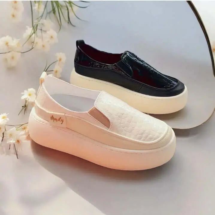 Par de mocasines Maxy en colores blanco y negro con textura tipo cocodrilo, suela gruesa y cómoda para uso diario, diseño moderno y casual ideal para mujeres que buscan estilo y confort, calzado versátil para combinar con diferentes outfits, fabricado con materiales duraderos y ligeros.