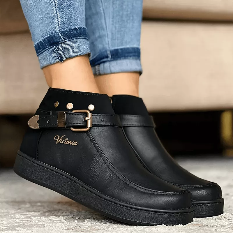 Botín negro para mujer en material sintético de alta calidad, con diseño elegante y cómodo, suela antideslizante ideal para uso diario, cierre lateral y detalle de hebilla decorativa que aporta estilo sofisticado, perfecto para combinar con jeans o pantalones casuales.