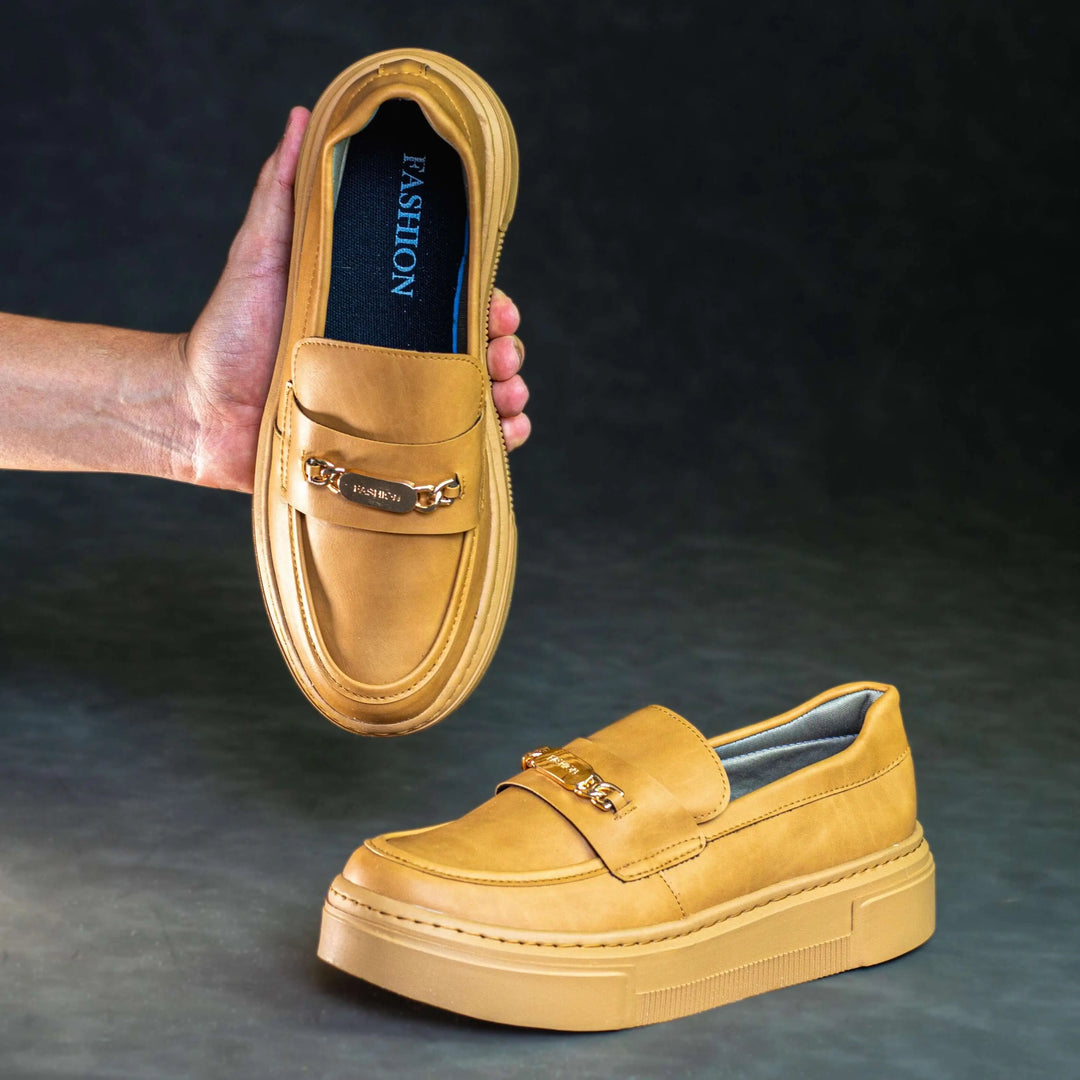 Mocasín color camel para mujer con suela gruesa antideslizante, diseño elegante con detalle metálico dorado, ideal para uso diario, comodidad y estilo moderno que aporta soporte y durabilidad.