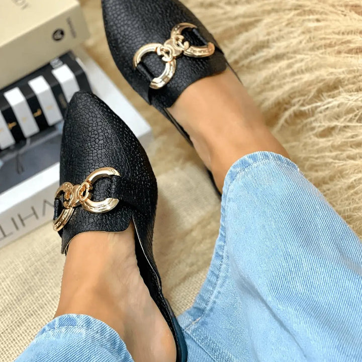 Sandalias suecas negras para mujer con diseño elegante y textura tipo piel, detalle en metal dorado, cómodas y versátiles, perfectas para uso diario y ocasiones formales, calzado femenino de moda que combina estilo y confort.