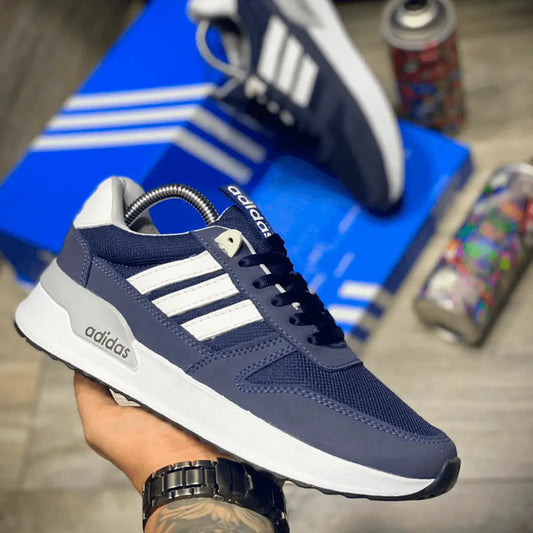 Zapato deportivo azul oscuro con detalles blancos, diseño moderno y cómodo, ideal para uso urbano y estilo casual, suela ligera que proporciona máxima flexibilidad y amortiguación para caminar todo el día sin fatiga, perfecto para hombres que buscan combinar estilo y confort en calzado casual.