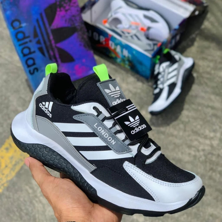 Zapatillas London en blanco, negro y gris, con malla transpirable, franjas laterales y suela de textura hexagonal.